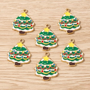 Gros plan détaillé de six breloques sapins de Noël en émail vert avec anneaux dorés