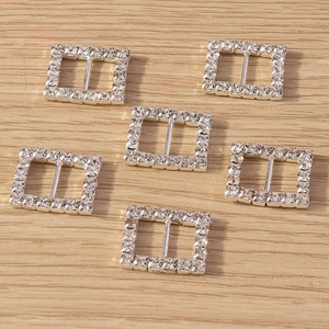 Macro detail of six silver square buckles with sparkling clear rhinestones on wood