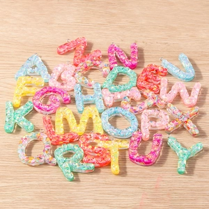 Colorful resin letter charms with vibrant glitter flakes and metallic hanging loops