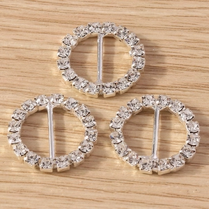 Close-up of three silver round rhinestone slider buckles for DIY craft and accessories