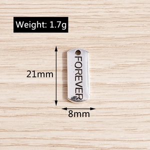 Detailed view of silver rectangular charm with Forever engraving for jewelry making