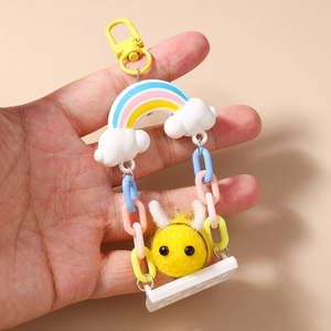 Close-up of cute bee plush keychain with colorful rainbow chain and metal clasp