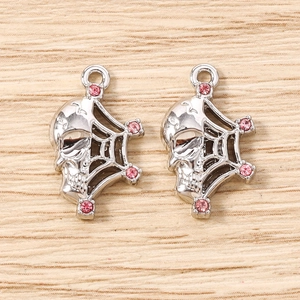 Detail of silver skull and spider web charm with pink rhinestones for jewelry making