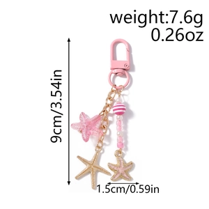 Porte-clés étoile de mer rose avec perles rayées et dimensions sur fond blanc pur