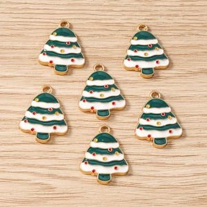 Détail de pendentifs sapin de Noël en émail vert et blanc sur bois clair