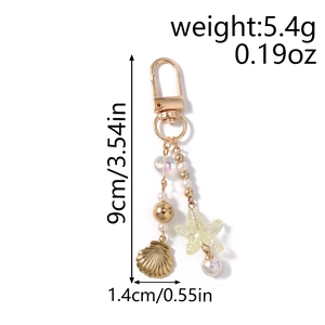 Detail of shell and starfish charms on a pearl heart keychain with size dimensions
