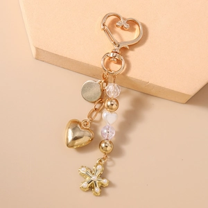 Porte-clés doré avec fermoir cœur, fleur en perles et pendentifs cœur élégants