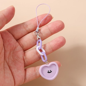 Détail d'un bijou de téléphone cœur violet avec smiley et chaîne en plastique durable