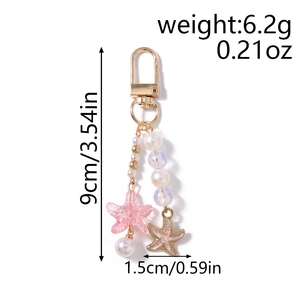 Detail view of pearl and starfish keychain pendant showing product dimensions and weight