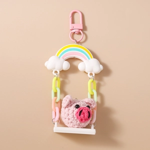 Detail of hand-knitted pig head keychain with colorful rainbow and plastic link chain