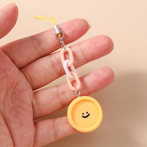 Détail du charm smiley jaune avec chaîne de téléphone en plastique rose et blanc