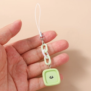 Détail d'un cordon de téléphone vert menthe avec pendentif carré souriant et anneaux