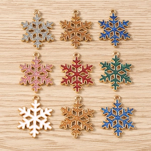 Vue détaillée de pendentifs flocon de neige à paillettes colorées avec bords dorés pour DIY