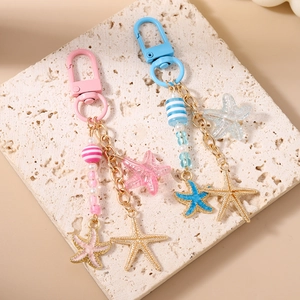 Vue détaillée de porte-clés perles étoile de mer roses et bleues avec breloques