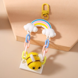Detail view of felt bee bag charm with rainbow cloud and macaron plastic chain