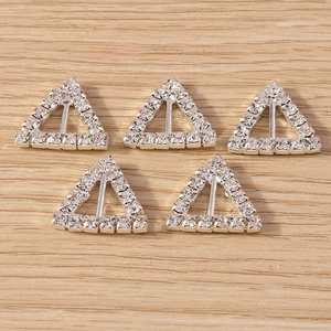 Close-up of triangle crystal pendants for DIY jewelry with silver metal and clear rhinestones
