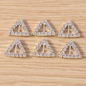 Detail of silver triangle rhinestone buckles with pave setting on wood background