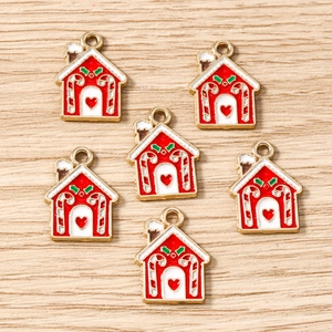 Vue à plat de six breloques de maison de Noël émaillées avec des toits enneigés