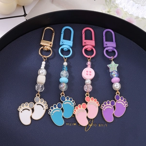 Set of four baby footprint keychains with colorful star beads and enamel charms