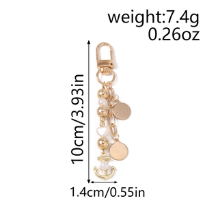Détail porte-clés ancre dorée avec perles et breloque cœur pesant 7,4g et mesurant 10cm