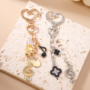 Porte-clés musical élégant avec perles et trèfle sur anneau en forme de coeur