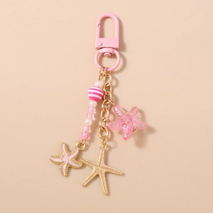 Détail du porte-clés étoile de mer rose avec breloques en émail et perles rayées
