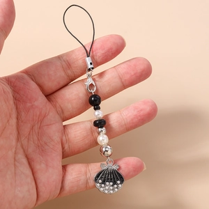 Close-up of ocean-style mobile phone strap with black shell pendant and pearls