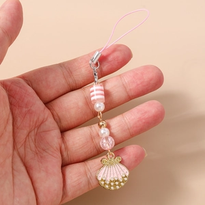 Close-up of pink shell phone charm with striped beads and pearls held in hand