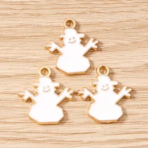 Détail de trois breloques bonhomme de neige en émail blanc avec bords dorés pour bijoux