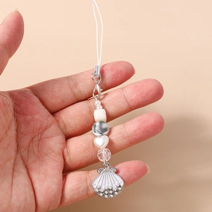 Close-up of beaded phone strap with shell pendant and silver lobster clasp in hand