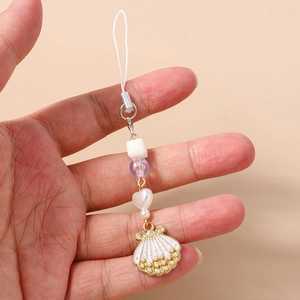Detail of white shell pendant and heart beads on a stylish mobile phone strap