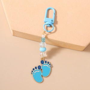 Detail of baby footprint pendant with light blue beads and gold metal D-ring clasp