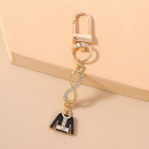 Detail of infinity charm with rhinestones and jacket pendant on gold keychain