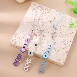 Three Halloween evil eye beaded phone charms with BOO charms on stone tray