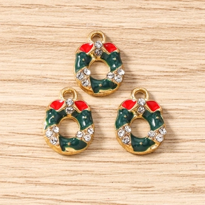 Gros plan de trois pendentifs couronnes de Noël dorés avec émail vert et strass brillants