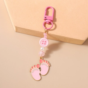 Close-up of pink enamel footprint charms and beaded keychain with lobster clasp