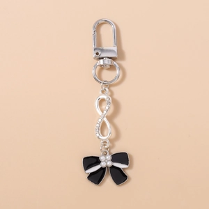 Detailed macro view of infinity symbol keychain with white rhinestones and a pearl bow charm