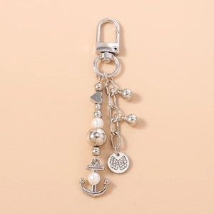 Détail du porte-clés perle argenté avec pendentif ancre et médaille nœud en strass