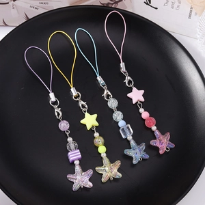 Close-up of four colorful beaded phone straps with stars and stripes beads on black tray
