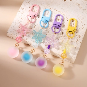 Starfish beaded keychains in pink, blue, purple, and yellow on stone background