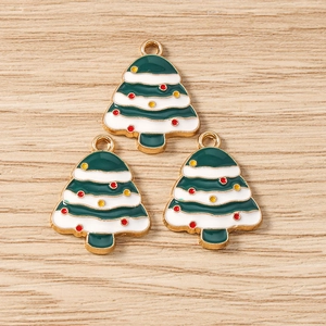 Détail de trois breloques sapin de Noël en émail vert avec bordure festive en alliage de zinc