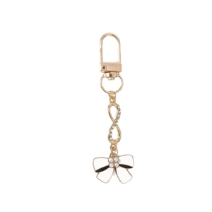 Fashionable gold infinity keychain with rhinestone detail and a white enamel bow charm