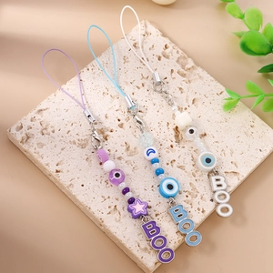 Detailed close-up of beaded evil eye phone charms in purple, blue and white colors