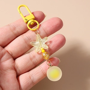 Detailed close-up of yellow beaded starfish keychain with frosted ball pendant
