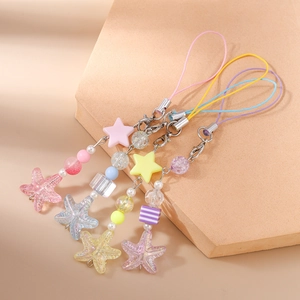 Detailed view of colorful macaron star and starfish beaded phone charms in four pastel colors
