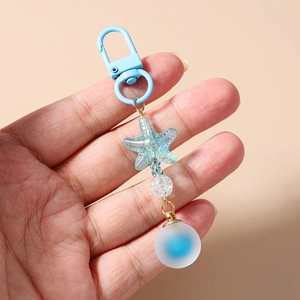 Close-up of ocean-themed beaded keychain with starfish bead and frosted gradient blue ball