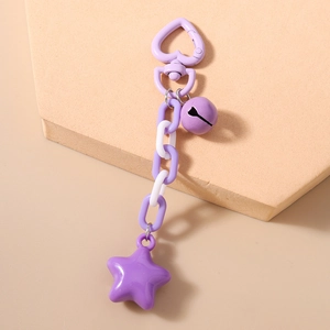 Detail of purple star keychain with heart clasp, bell, and pastel chain links