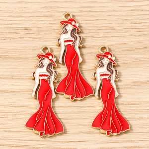 Detalle de dijes de modelo femenina en esmalte rojo y blanco para joyería artesanal