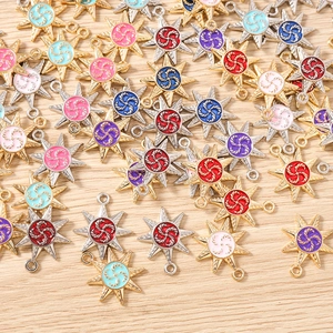 Macro view of colorful star charms with enamel swirl patterns and gold and silver bases