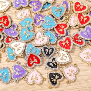 Detailansicht von Herzanhängern mit goldener Schleife und Strasssteinen für DIY-Schmuck